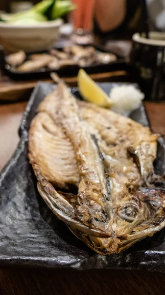 Poisson servi pendant la cuisson sur le plat au restaurant japonais izakaya — Photo