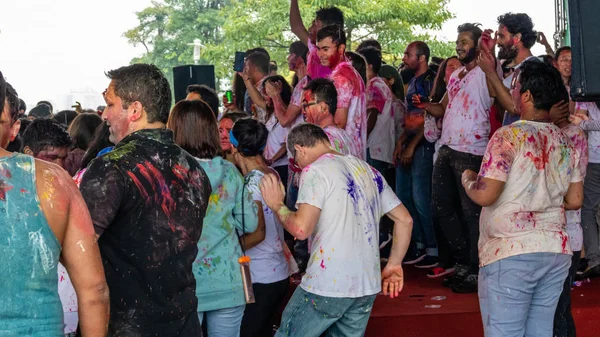 Счастливые люди танцуют и празднуют Холи фестиваль цветов Стоковое Изображение