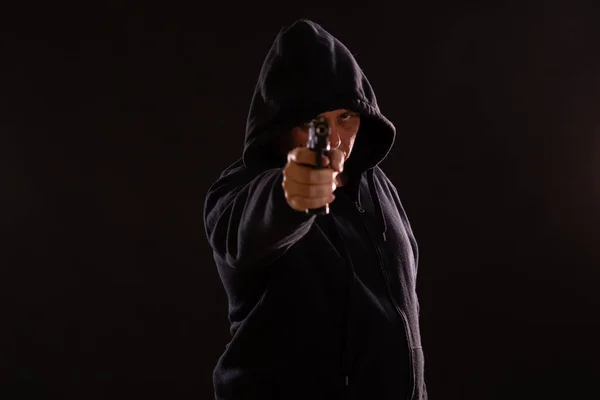 Mannen i svart hoodie punkter pistol — Stockfoto