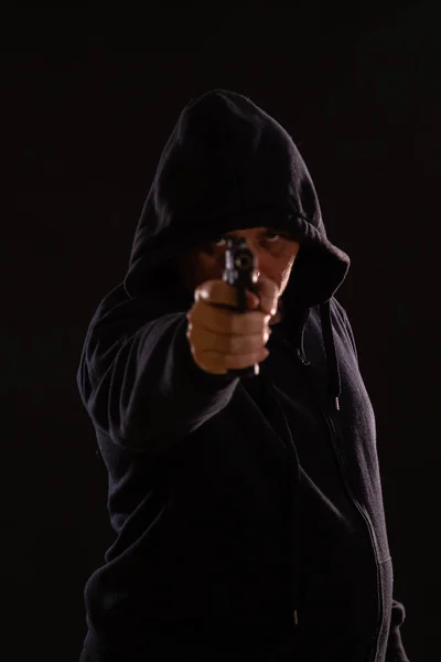 Hombre con capucha negra apunta pistola — Foto de Stock