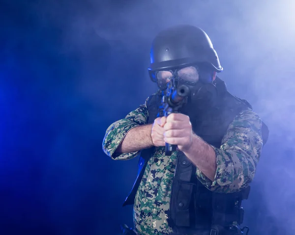 Soldado segurando rifle de assalto na névoa fumegante — Fotografia de Stock