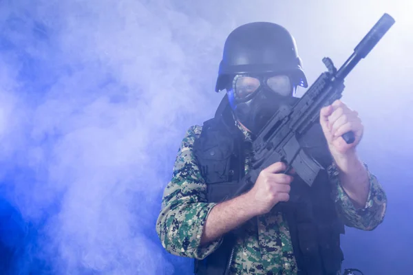 Soldado segurando rifle de assalto na névoa fumegante — Fotografia de Stock