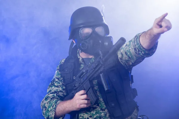 Солдат держит автомат в дымке — стоковое фото