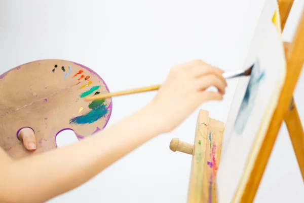 Artist painting oil painting on an easel — Stock Photo, Image