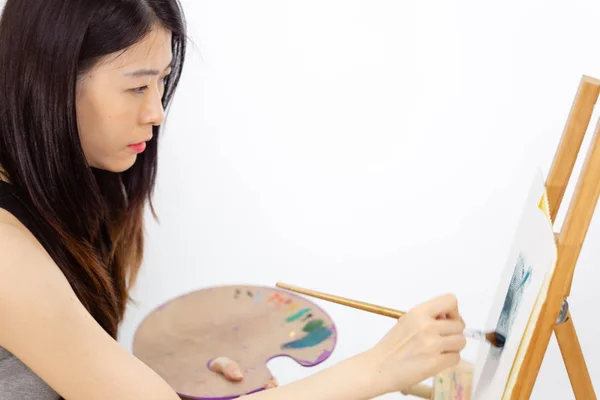 アジア系アメリカ人アーティストがイーゼルに絵を描く — ストック写真