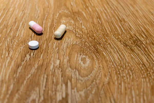 Capsules and pill on table — Stock Photo, Image