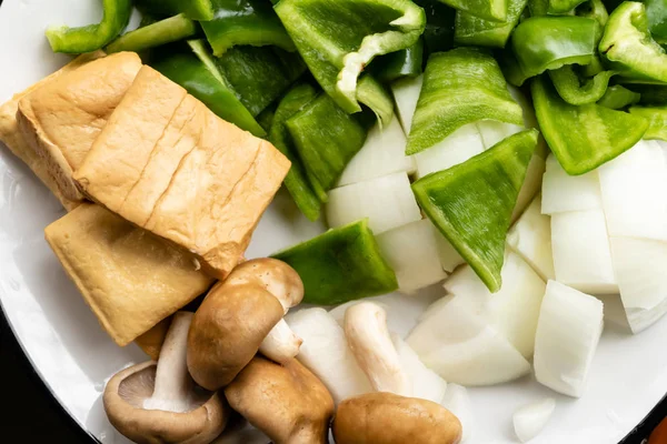 Poivrons verts, tofu, oignon et champignons dans une assiette — Photo