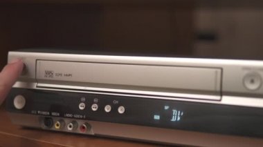 Turist çekim yapıyor. Fotoğrafçı fotoğraf çekiyormuş. Etrafta çiçekler var. Arka planda Moskova Devlet Üniversitesi