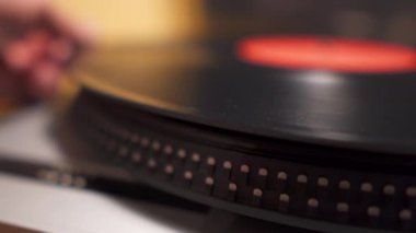 Plakçalar yakın çekim görünümünde vinil disk yerleştiriliyor ve çıkarılıyor