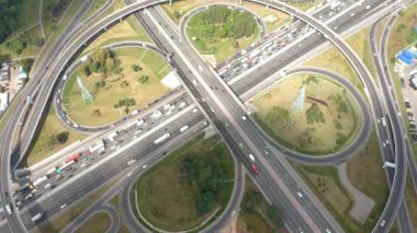 Büyük yonca kavşağı hareket halinde. Yol trafiği gerçek hızda. Bulutlu güneş.