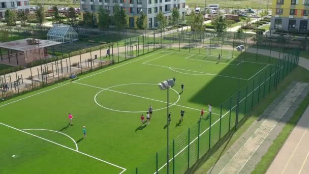 Niños jugando al fútbol en el patio. Zona de juegos dentro de zona residencial. — Vídeos de Stock