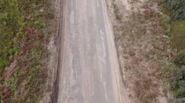 Tozlu ve boş yolda yukarıdan yukarıdan aşağıya doğru manzara. Trafik olmadan. İlerleyin. Yüksek açı. Yüksek kalite 4K görüntü, İHA 'dan havadan çekilmiş. Yukarıdan bak.