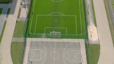 Dışarıdaki futbol insansız hava aracının en üst görüntüsü. Futbol oynayan insanlar. Oyun parkı. İHA 'nın 4K' lık görüntüsü çok kaliteli. Yukarıdan bak.