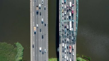 Nehir üzerinde büyük bir trafik varken, çift köprüyü geçmek için düz hareket. Yukarıdan aşağıya doğru. İHA 'dan yüksek kalite 4K görüntüler