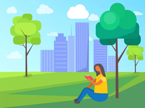 Woman Sits on Grass in City Park and Reading Book