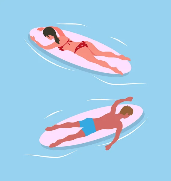 Man and Woman Swimming on Surfboards in Blue Sea