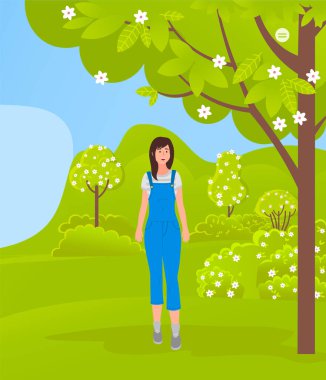 Genç bir kız çiçek açan bir parkın ya da ormanın ortasında duruyor. Güzel doğa. Kentsel yaşam tarzı