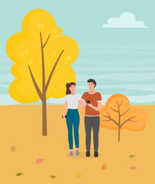 Parkta yürüyen bir çift. Genç adam ve kız el ele tutuşuyor sonbahar bahçesinde yürüyor, romantik bir yürüyüş