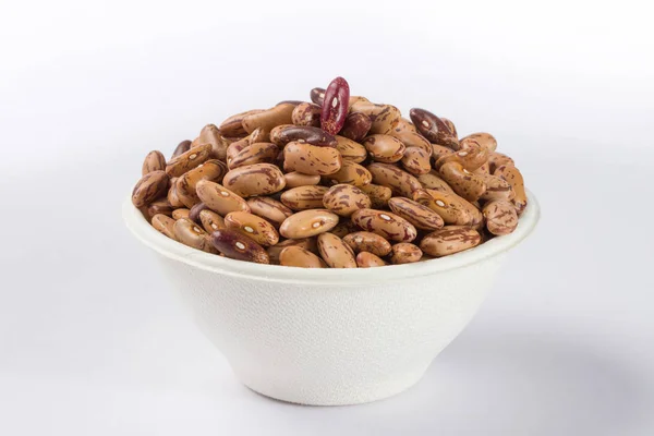 Beyaz arka planda beyaz kase çiğ barbunya yığını