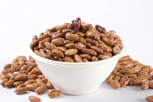 Beyaz arka planda beyaz kase çiğ barbunya yığını