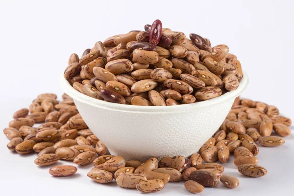 Beyaz arka planda beyaz kase çiğ barbunya yığını