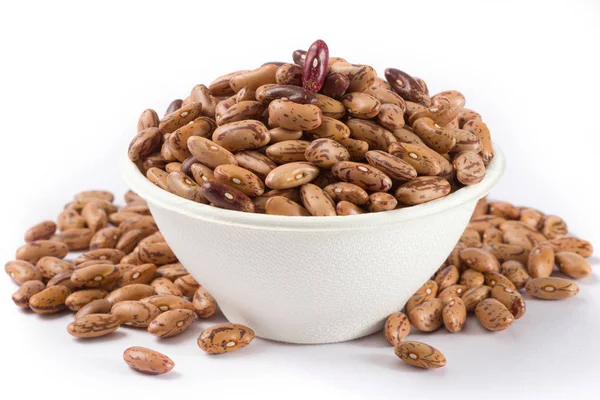 Beyaz arka planda beyaz kase çiğ barbunya yığını