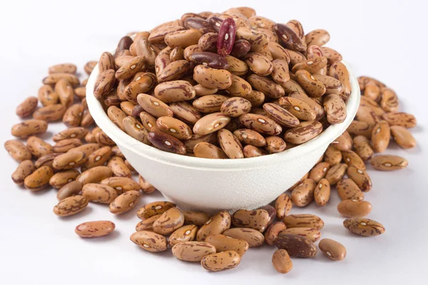 Beyaz arka planda beyaz kase çiğ barbunya yığını