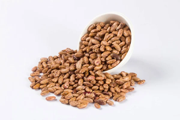 Beyaz arka planda beyaz kase çiğ barbunya yığını