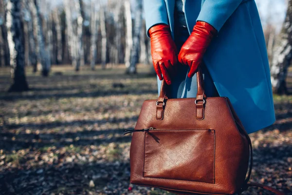 Güzellik ve moda. Kahverengi çanta çanta tutan parlak elbise giyen şık şık kadın