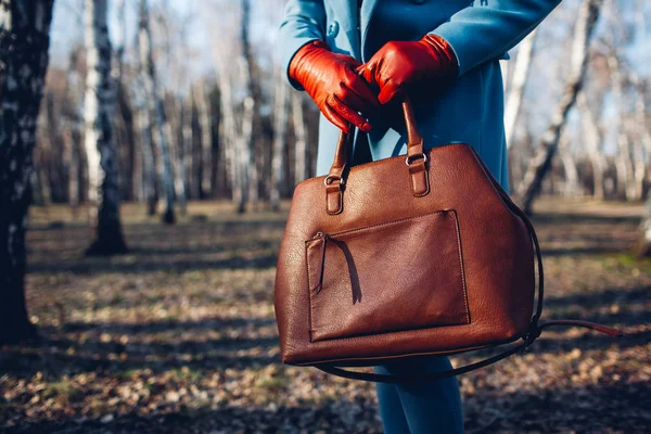 Güzellik ve moda. Kahverengi çanta çanta tutan parlak elbise giyen şık şık kadın