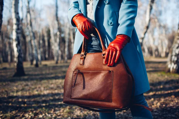 Güzellik ve moda. Kahverengi çanta çanta tutan parlak elbise giyen şık şık kadın