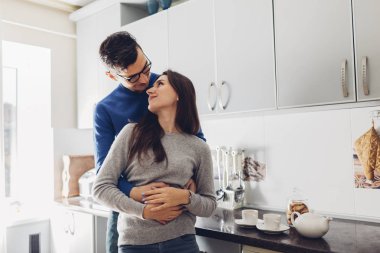 Mutfakta çay içen genç bir çift var.