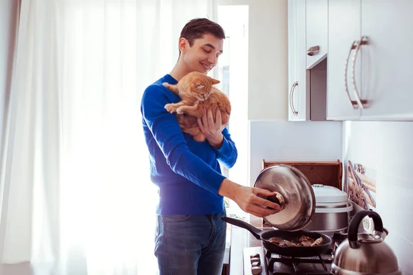 Mutfakta kedi ile yemek yakışıklı genç adam Portresi