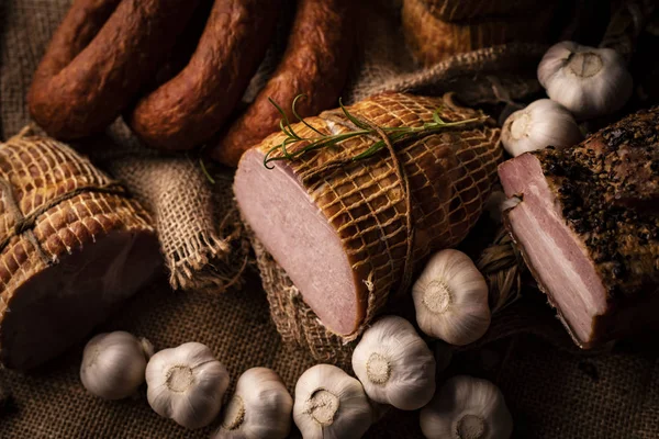 Jamón de cerdo ahumado, tocino y salchichas. Una composición casera de embutidos . —  Fotos de Stock