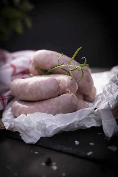 White sausage. Traditional raw white sausage on a wooden background.