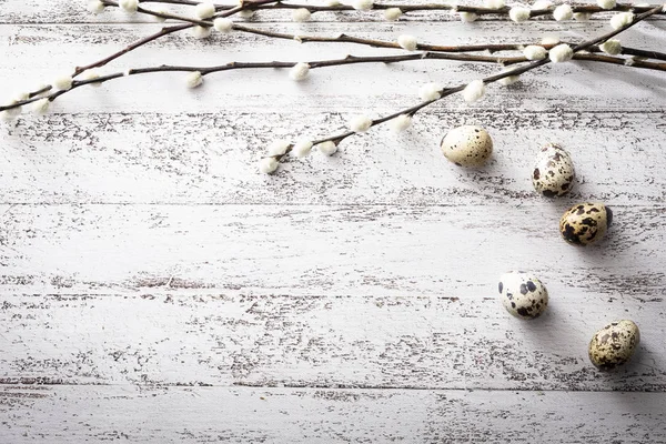 Easter, quail eggs and willow branches on a wooden background — Stock Photo, Image