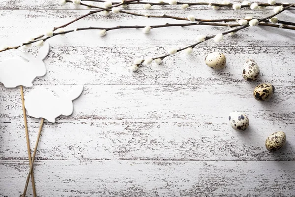 Пасхальный праздник с перепелиными яйцами, ивовыми ветвями и пасхальным кроликом на деревянном фоне — стоковое фото