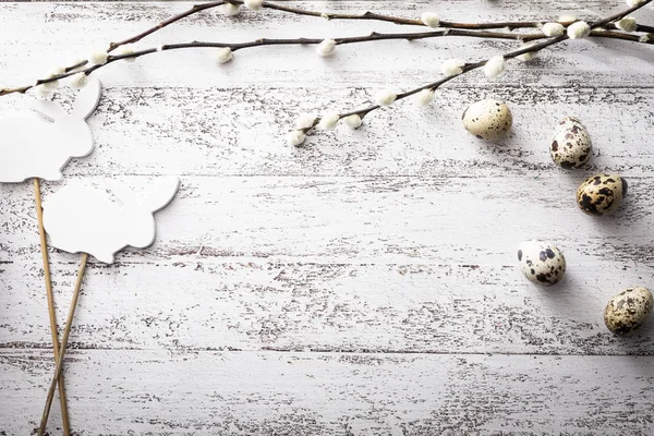 Pascua, huevos de codorniz, ramas de sauce y conejito sobre un fondo de madera —  Fotos de Stock