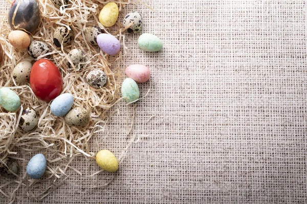 Пасхальные, разноцветные перепелиные яйца на льняном фоне . — стоковое фото