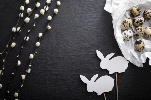 Tło wielkanocne. Naturalne Jaja przepiórcze, gałęzie wierzby i króliczka Wielkanocna na ciemnym tle — Zdjęcie stockowe
