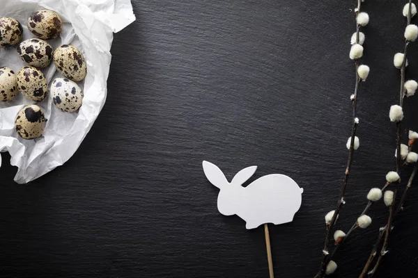 Пасхальные натуральные перепелиные яйца, ветви ивы и пасхального кролика на тёмном фоне — стоковое фото