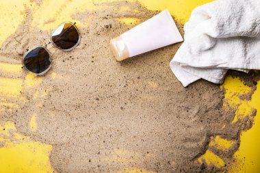 Metin alanı ile altın kum arka planda plaj aksesuarları.