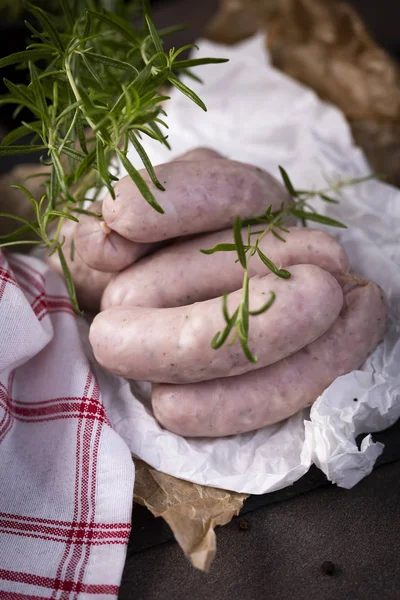 White sausage. Traditional raw white sausage on a wooden background.
