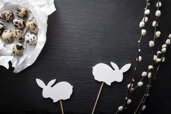 Black and white Easter.  Natural quail eggs, willow branches and easter bunny on a dark background — Stock Photo, Image