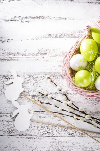 Easter decorations. A warm Easter wicker basket, sands and colorful palms. — Stock Photo, Image