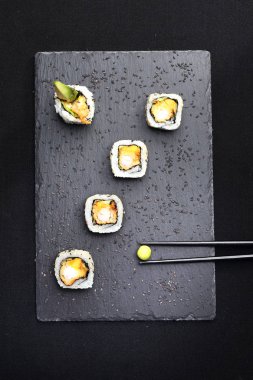 Sushi, tempura ve avokado karides ile. Siyah arka planda ayarlama