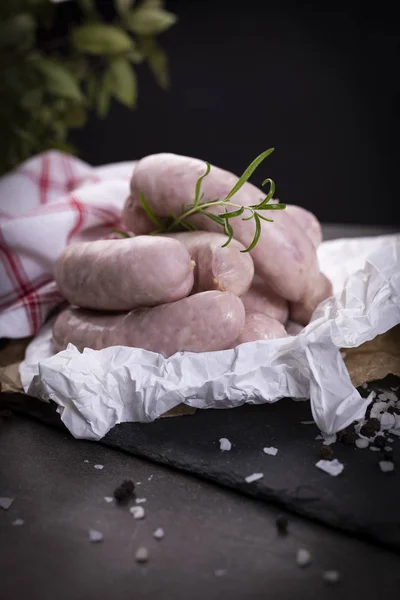 White sausage. Traditional raw white sausage on a wooden background.