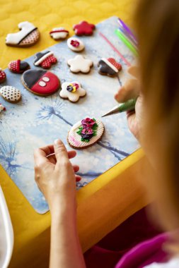 Kurabiyeler krema ile süslenmiş. Iştah açıcı renkli kurabiyeler.