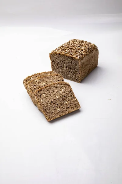 Brood met een mal, donker brood met zaden op een witte achtergrond. — Stockfoto