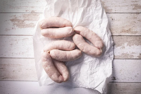 Salsiccia bianca. Salsiccia bianca cruda tradizionale su fondo di legno . — Foto Stock